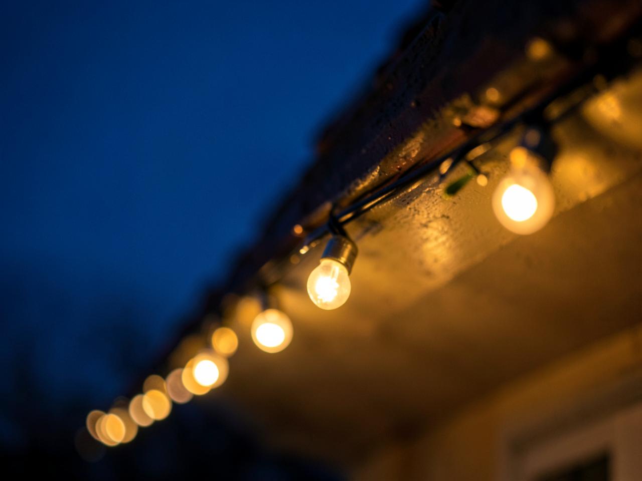 Warm gold bulbs clipped along a roofline at dusk
